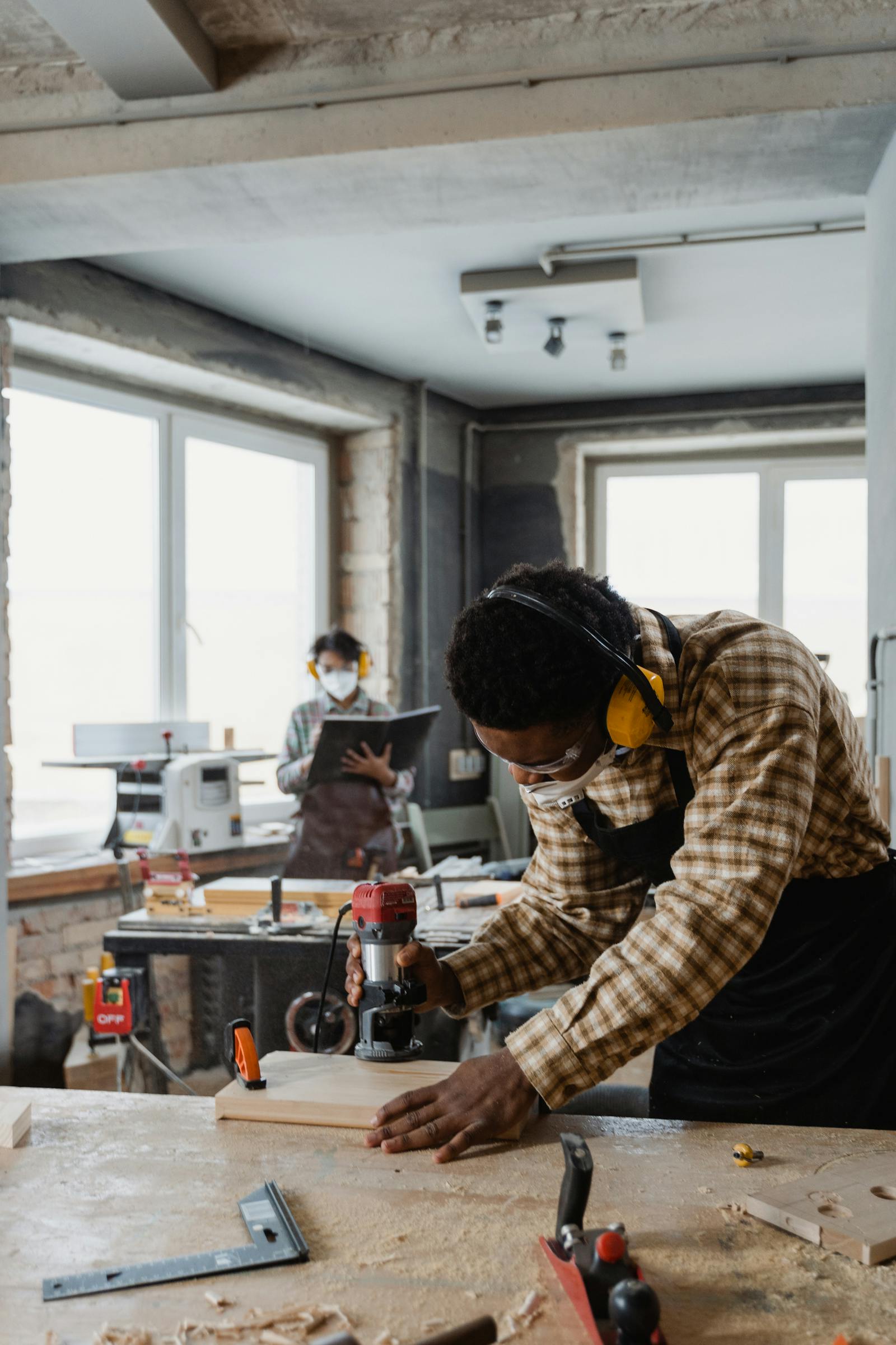Carpenter using a power tool for wood furniture finishing and maintenance