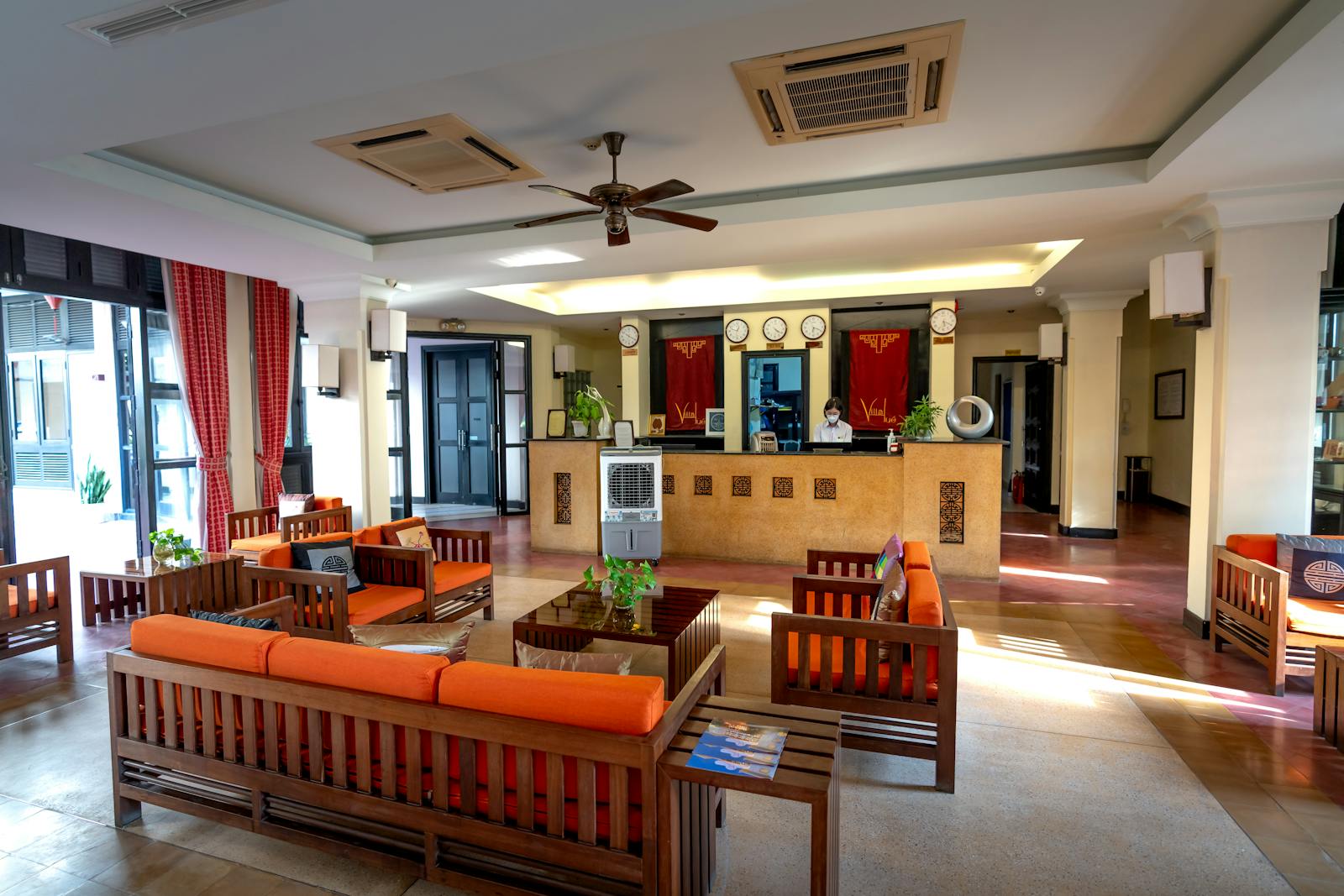Modern hotel lobby with reception counter, sofas, and guest seating
