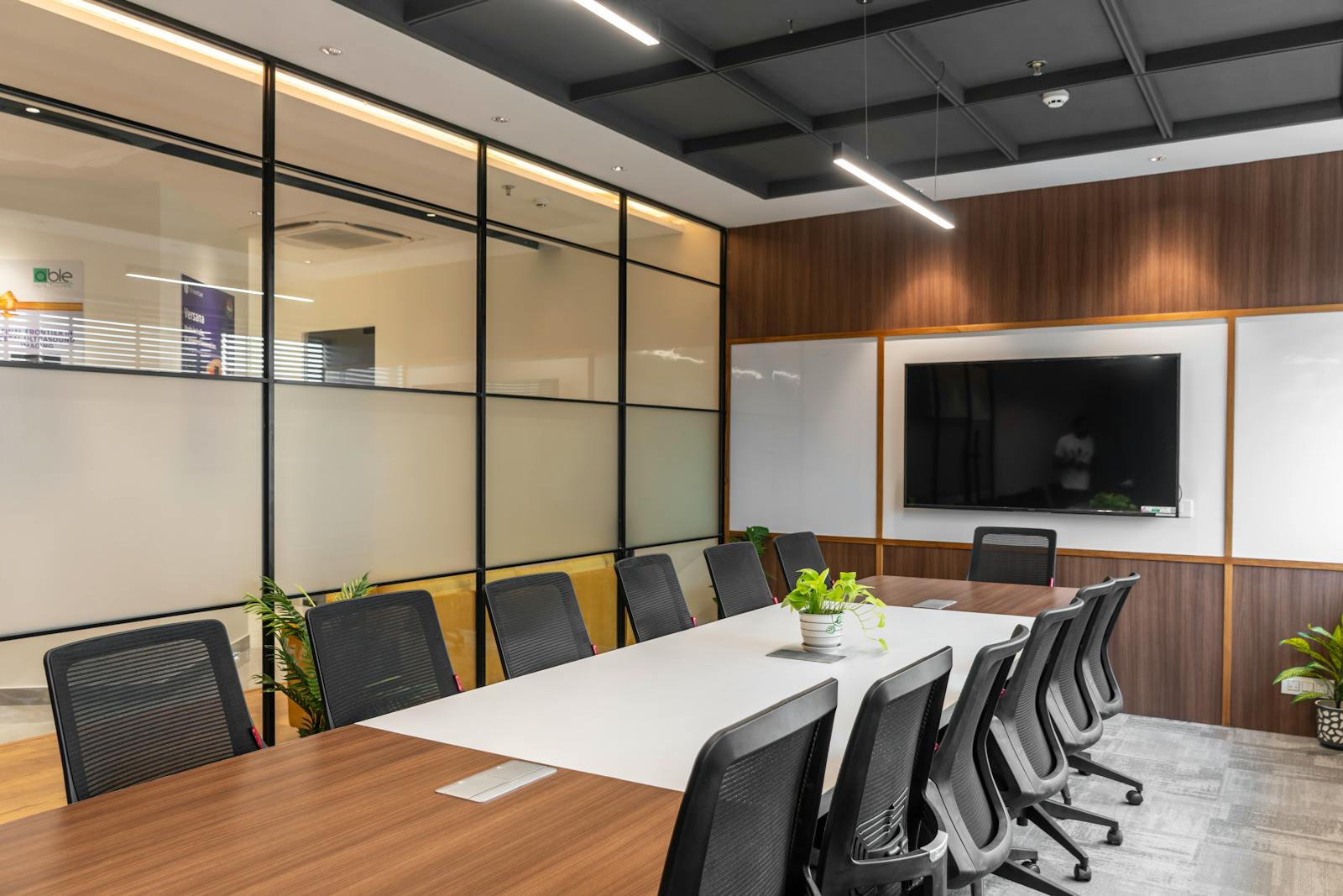 Modern executive meeting table with premium chairs and wood wall panels