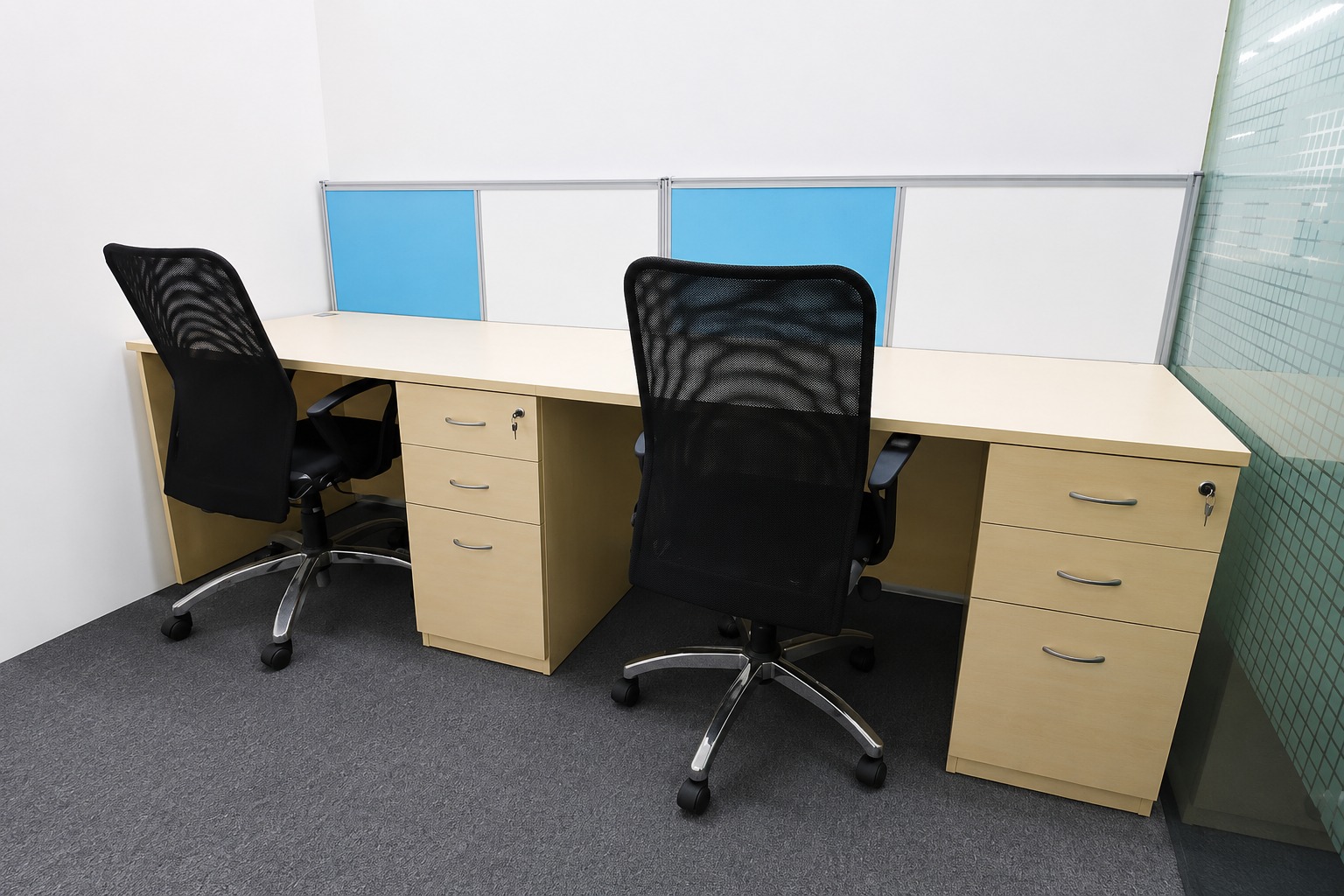 Fitted office desks with mesh chairs and individual drawer units